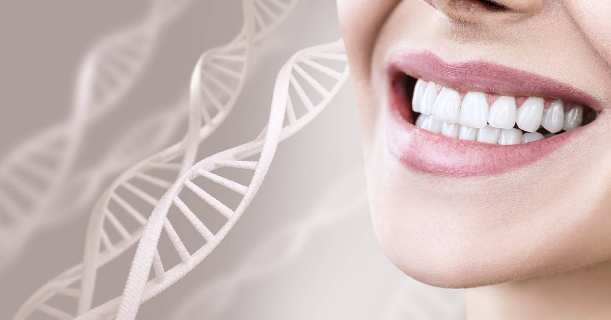 A woman has a wide smile and showcases healthy teeth at close range. Small, white DNA strands are in the background.